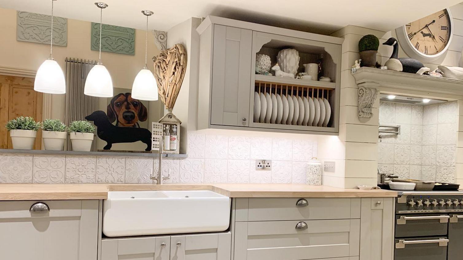 Grey shaker kitchen with a wall-mounted kitchen storage idea for displaying plates and crockery.
