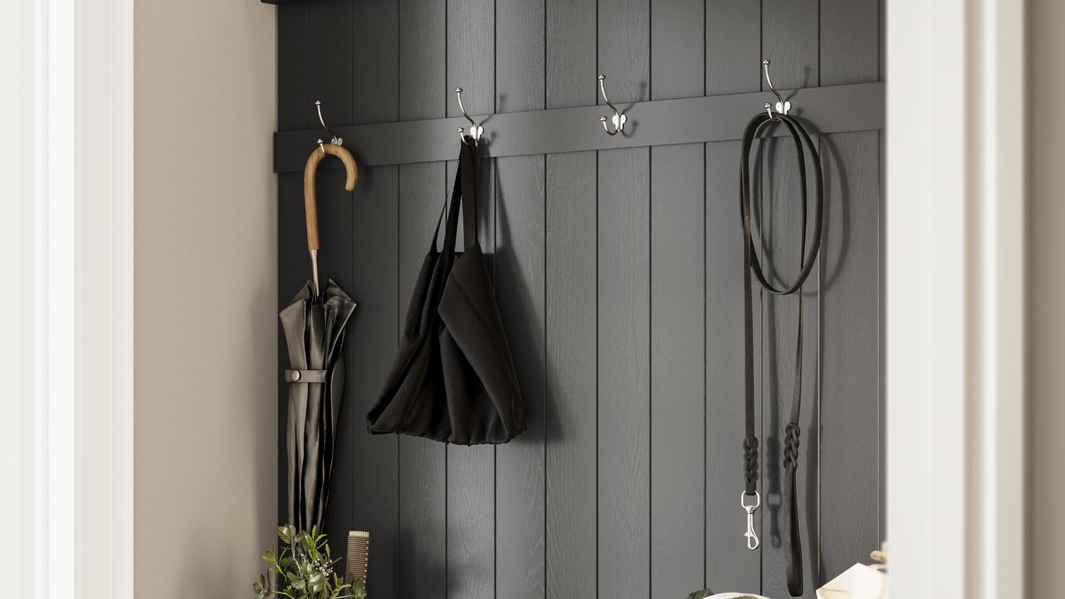 A utility room with hooks used to hang up a bag and umbrella, with a bench made from kitchen cabinets.