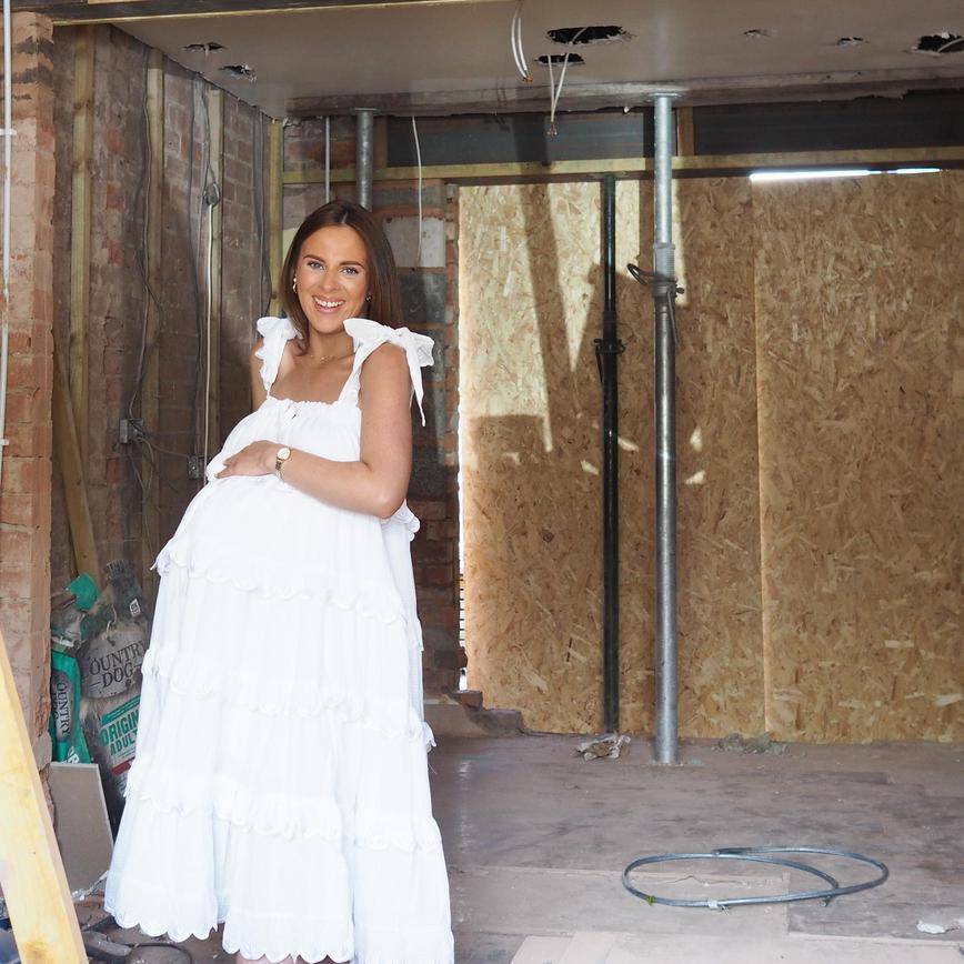 Woman in white dress standing in a kitchen a renovation