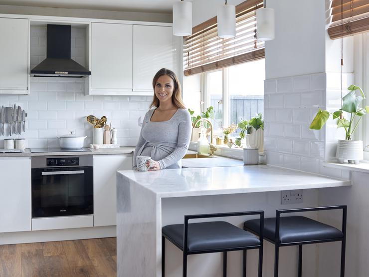 Woman in white gloss integrated handle with breakfast bar
