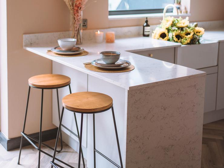 White marble quartz worktop  on a breakfast bar with brown bar stools