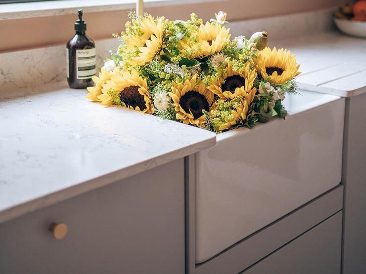 Ceramic Belfast single bowl sink with brass tap, white marble worktop and sunflowers