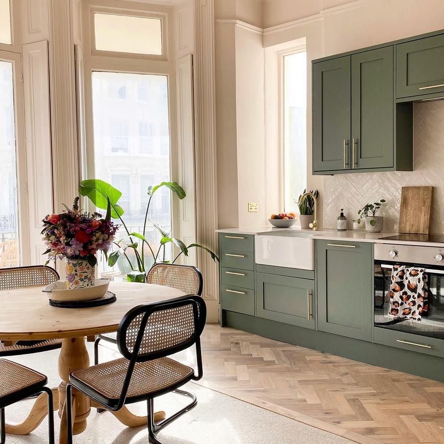 Flat renovation using a green shaker kitchen design in a single wall layout. Includes herringbone flooring.