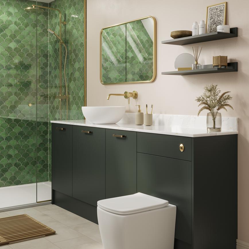 A Hockley green bathroom with dark cabinets & sink with gold accessories. Inside are toilet, sink, & tiled flooring.