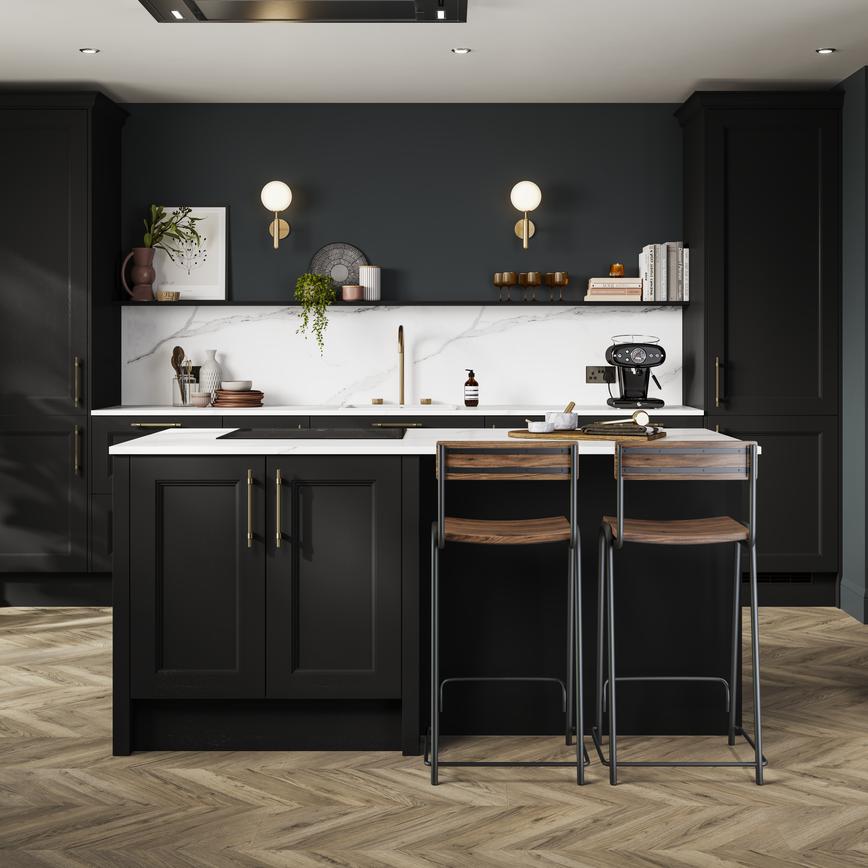 A charcoal black shaker kitchen in a single-wall layout, with island. There are white worktops and chevron oak flooring. 