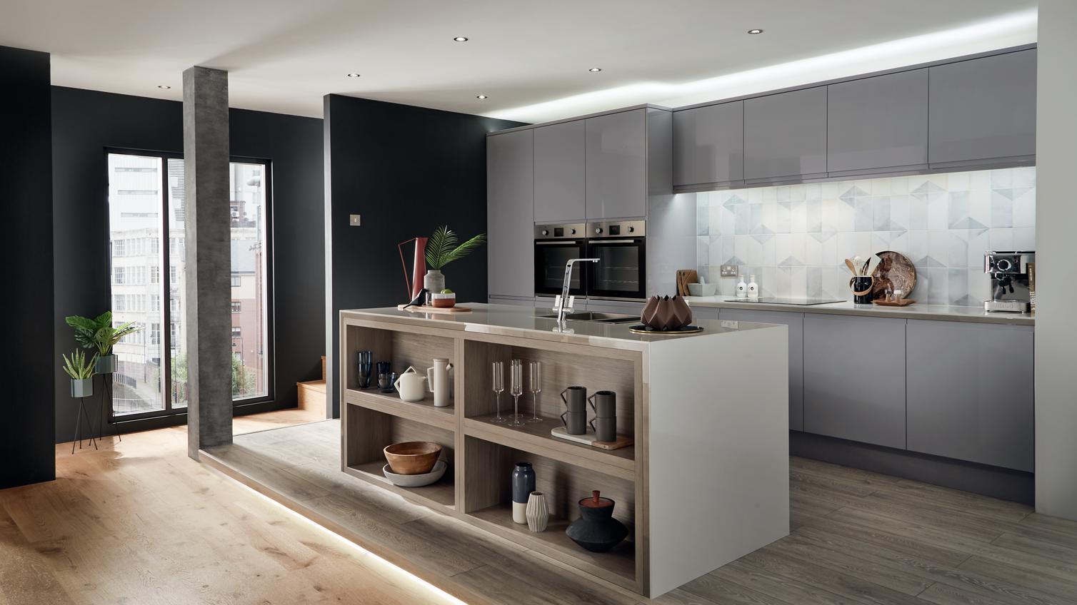 Slate grey modern handleless gloss kitchen in an apartment setting including kitchen island incorporating exposed shelving.