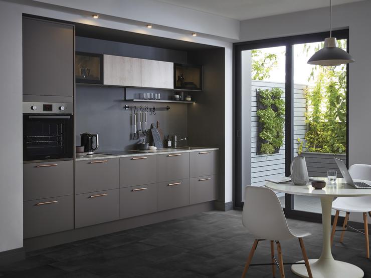 Single wall kitchen with graphite grey kitchen doors and built in oven with patio doors leading to a garden area.