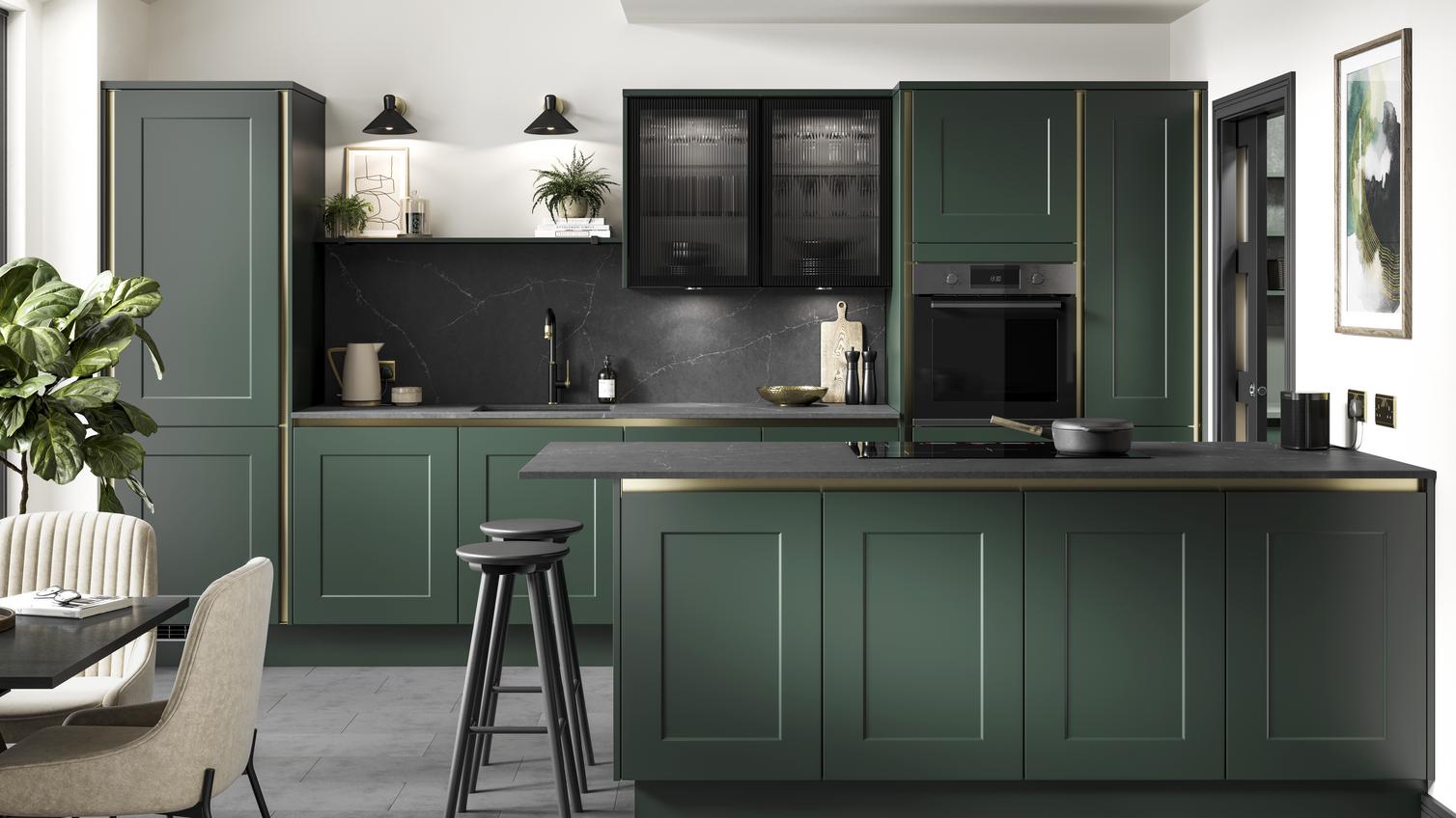 A fir green kitchen idea with handleless shaker cupboard doors in a peninsula layout. Has black worktops and brass profiles.