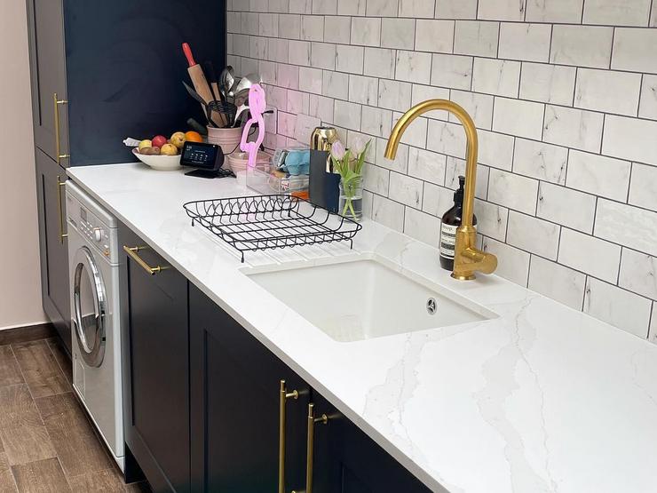 Navy shaker kitchen idea with brass bar handles, a brass mixer tap, white marble worktops, and a white undermount sink.