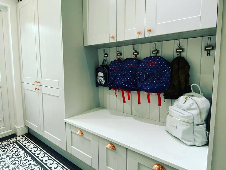 Boot room storage idea using different depths of cabinets to create a spacious seating area.