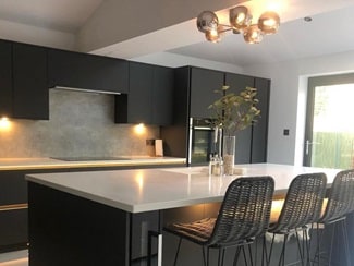 Black handleless kitchen with stone worktops and downlights for lighting