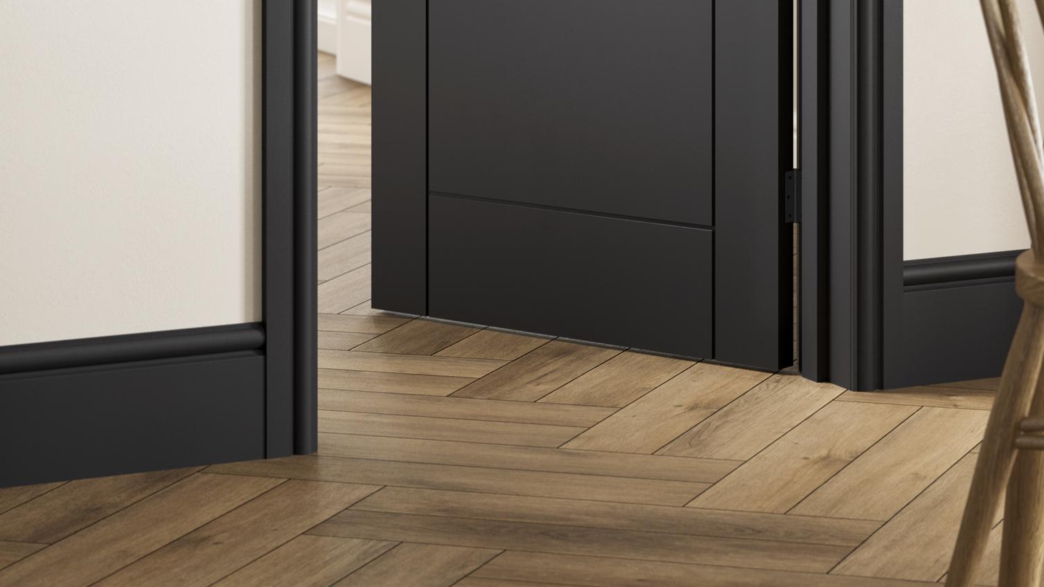 Black internal door in a dining room with five panels, plus matching black skirting boards next to a chevron floor.