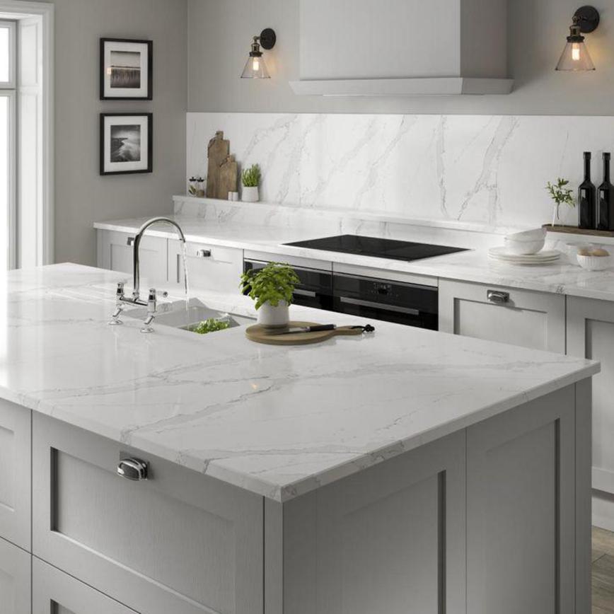A marbled white silestone island surface in a grey kitchen