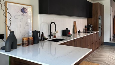 Mix and match kitchen idea featuring black and walnut units. Also includes a white worktop, a black sink, and chevron floors.