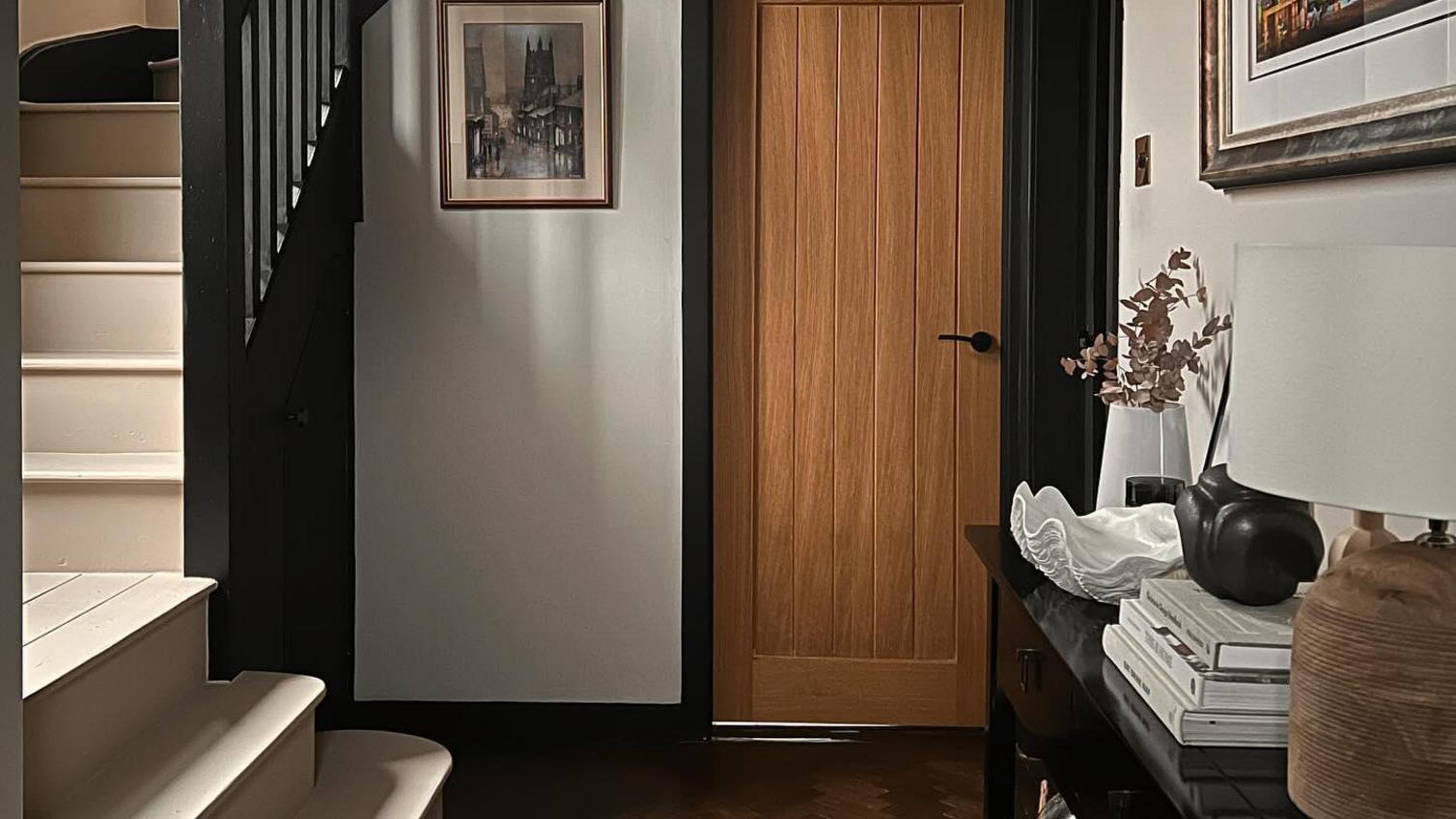 An oak internal door in a real-world design by inside_the_painted_door. It is paired with a black frame and door hardware.
