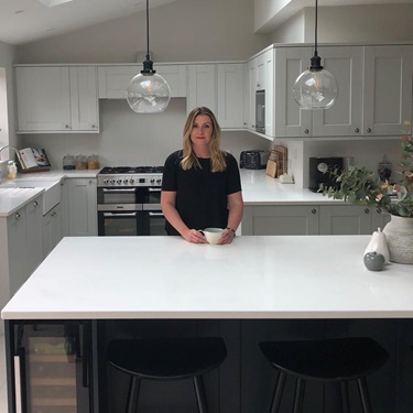 lady in black shirt standing behind navy kitchen island