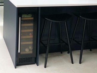 black win cooler on left hand side of navy kitchen island