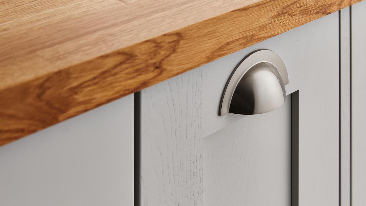 Close up of a metallic handle on a cupboard door