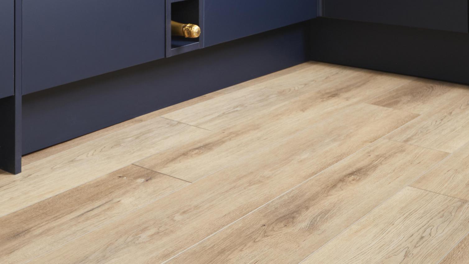 Oake & Gray branded vinyl flooring, with a light oak-effect finish. Fitted alongside navy cabinet door fronts.