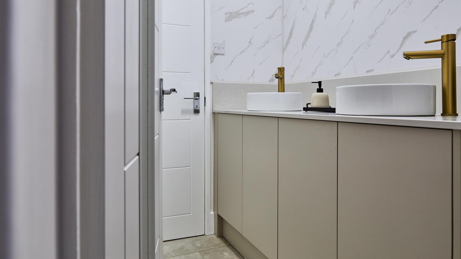 Jill Scott Cafe Kitchen Makeover bathroom with sandstone slab units., a white door, and tile-effect flooring