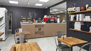 Jill Scott Cafe Kitchen Makeover with a white, laminate counter, oak wall panelling, and a black kitchen
