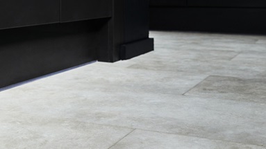 Jill Scott Cafe Kitchen Makeover with cream tile-effect flooring from Oake & Gray. Features black kitchen cabinets.