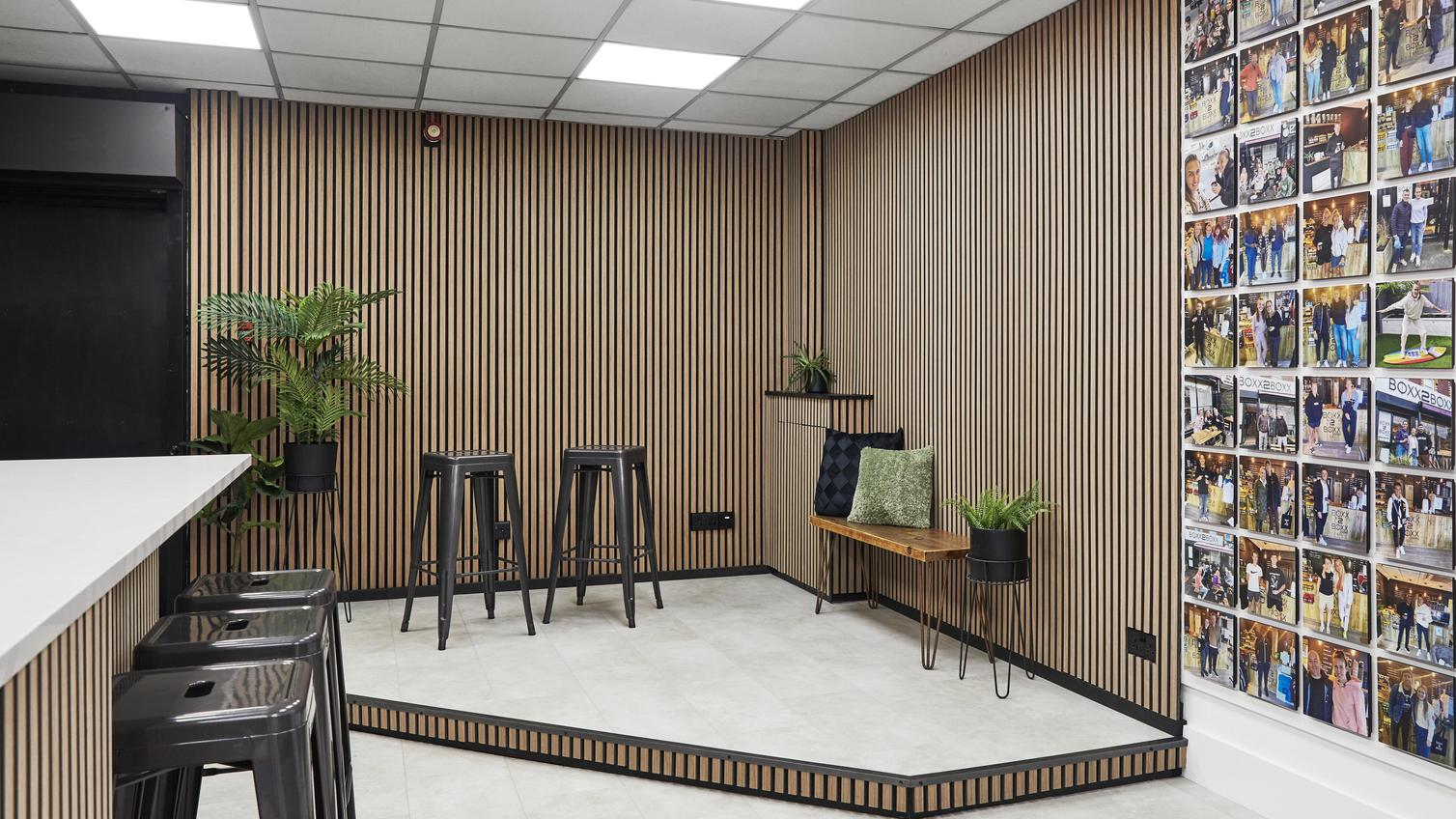 Jill Scott Cafe Kitchen Makeover with a stage that includes oak wall panelling, black bar stools, and cream, tile-effect floors.