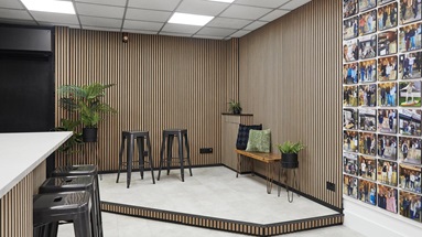 Jill Scott Cafe Kitchen Makeover with a stage that includes oak wall panelling, black bar stools, and cream, tile-effect floors.