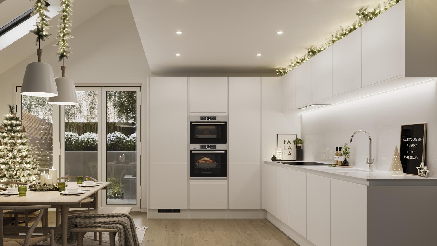 a white kitchen at christmas with a tree, fairy lights and garlands.