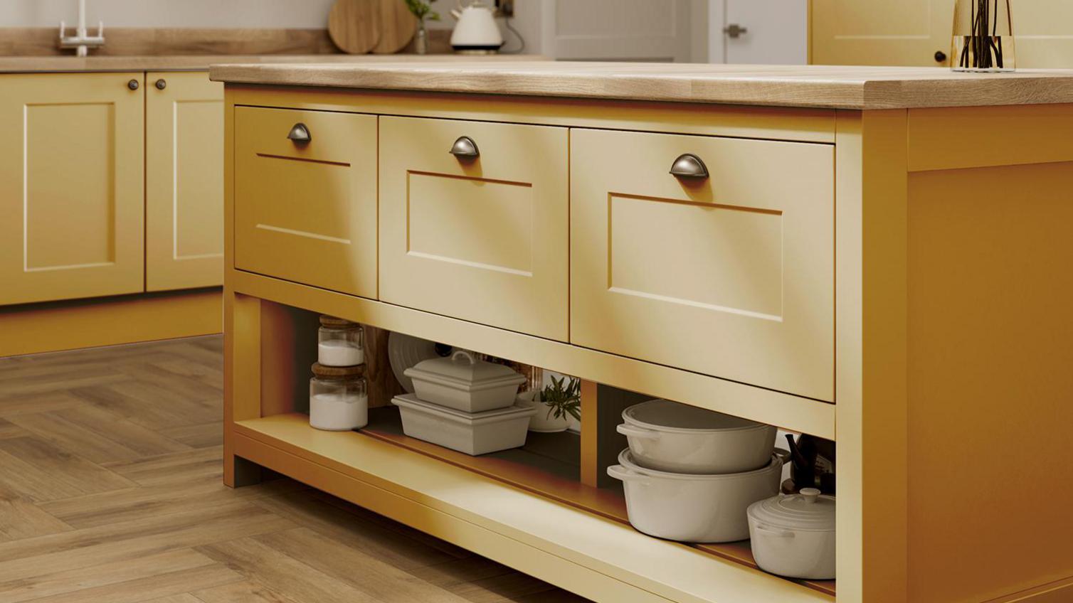 Yellow paintable kitchen idea with an island layout, shaker cupboards, oak herringbone flooring and matching oak worktops.