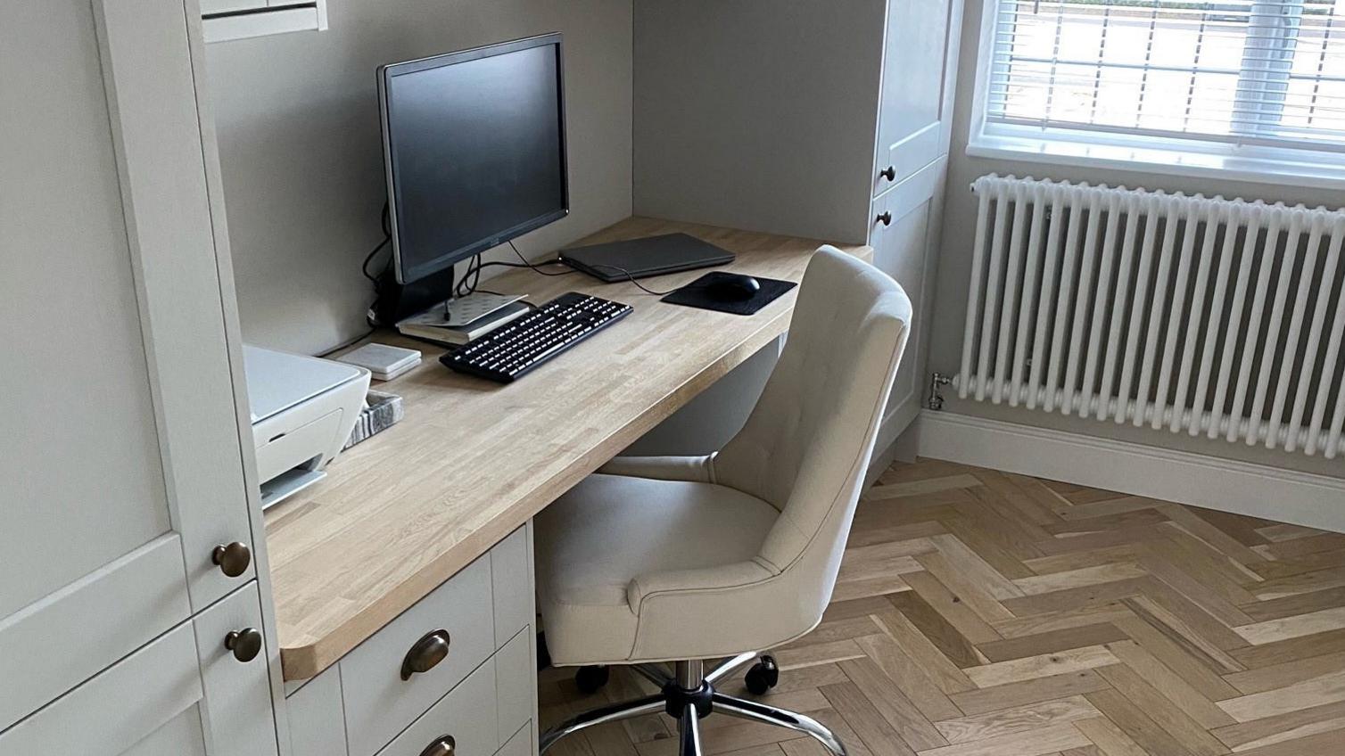 Dove-grey shaker style home office design, showing wall and base units, black knob and cup handles, light oak work surface.
