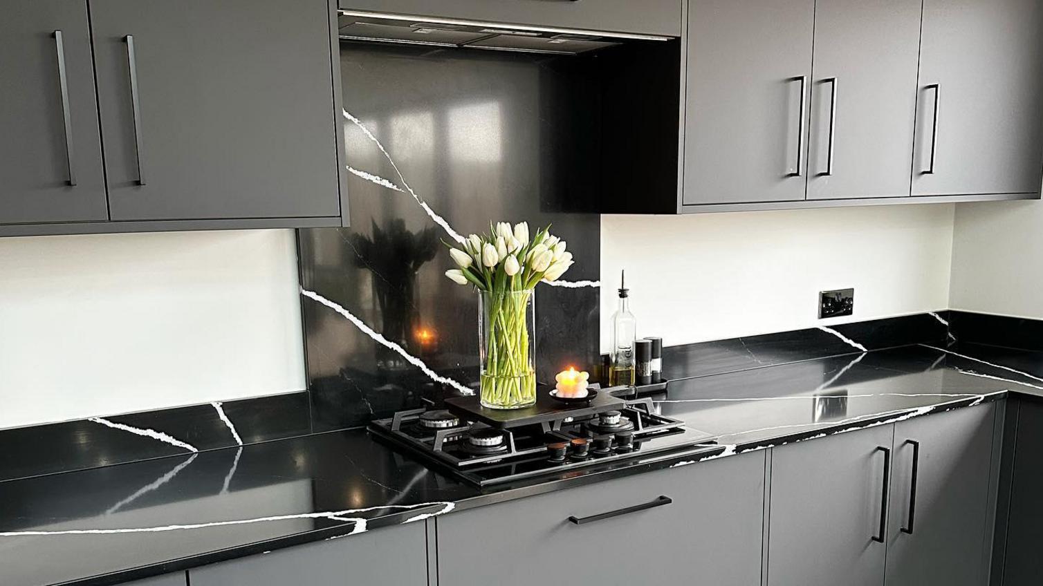 Bespoke worktop idea featuring black marble worktops with a matching upstand and splashback.