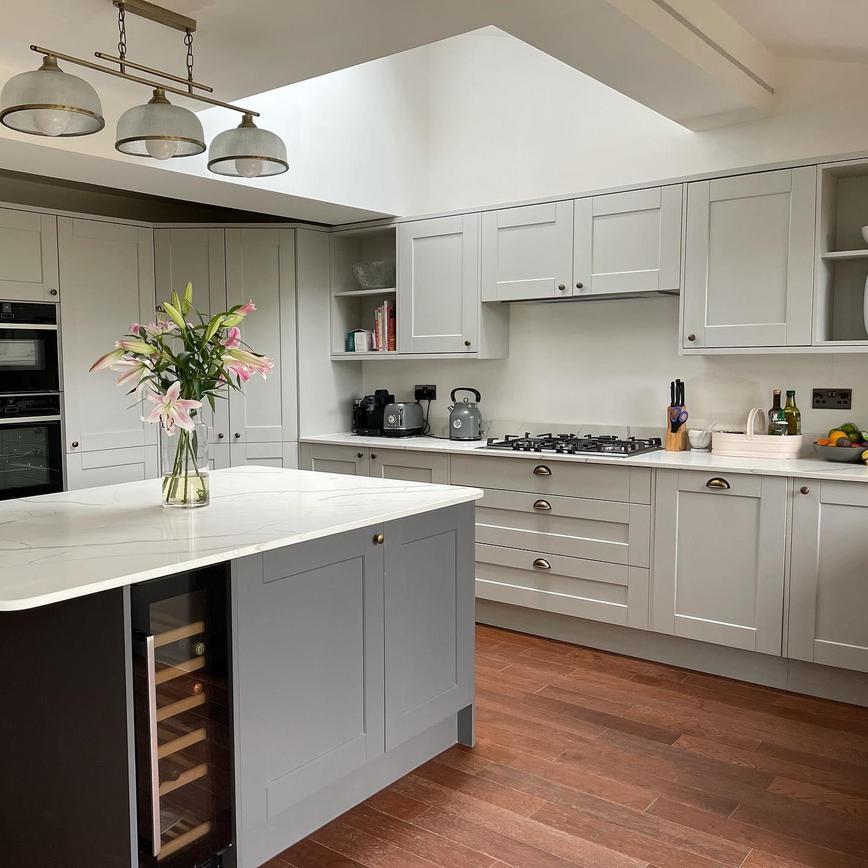 Light and dark grey kitchen design with shaker doors, silver cup and knob handles, white marble worktops.
