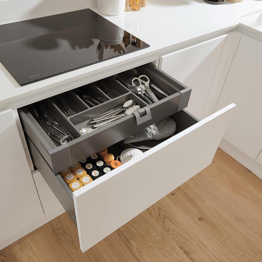 White deep kitchen drawers and internal storage fittings with cutlery and pan fixtures.