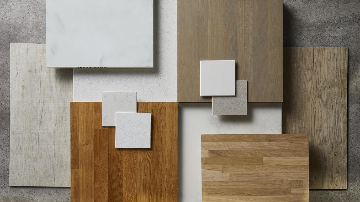 Crafted flat lay showing several square white and marble worktop samples and different oak slabs laid on top of each other.