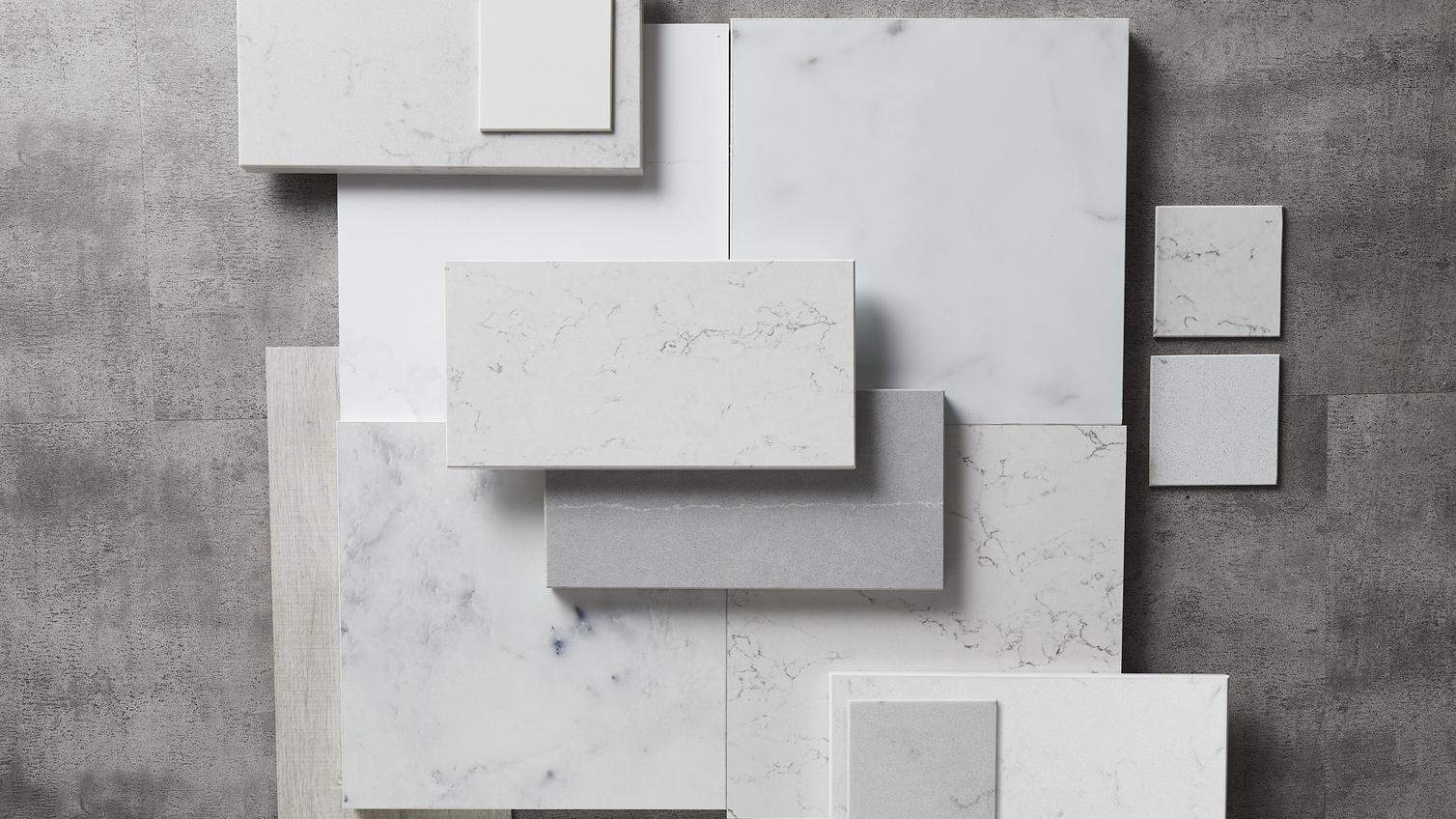 Elegance flat lay with different square slabs, including white and grey marble laid on top of each other.