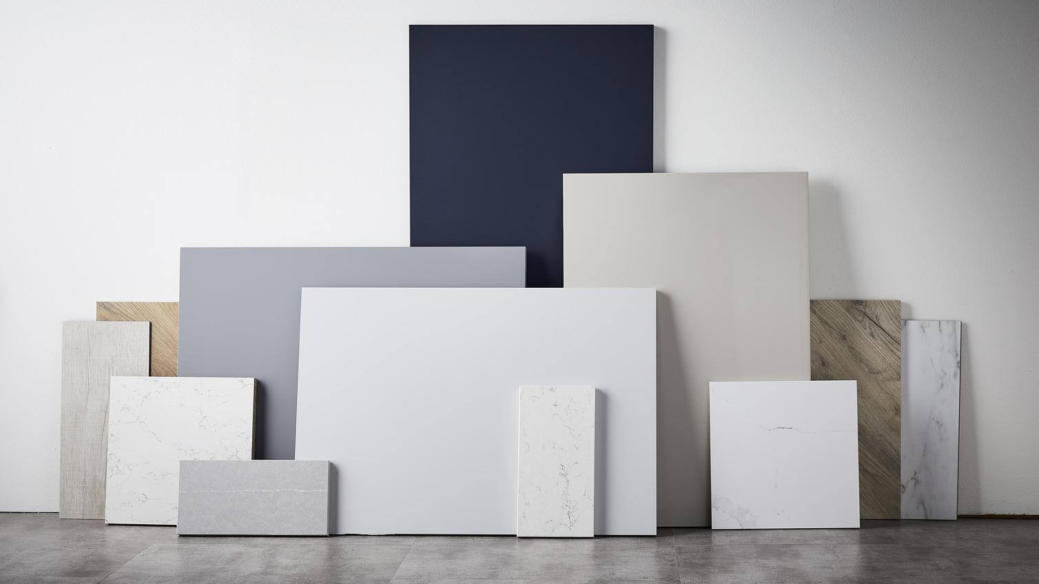 Elegance flat lay with different square slabs, including navy doors, and grey marble laid on top of each other.