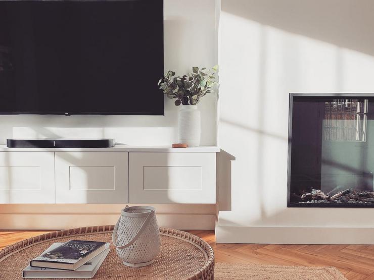 Minimal living room idea with a bespoke, wall-hung TV unit made from white, shaker cupboard doors with a smooth finish.
