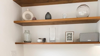 Home office idea with dark oak desk, black integrated handle drawers, oak open shelving and decorative accessories.