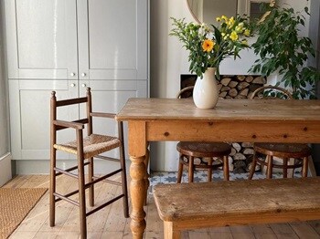 Farmhouse dining room idea with a light grey tower cupboard, a dark solid wood dining table, bench and stool chair.