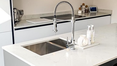A modern kitchen sink idea using a stainless-steel sink in a 1.5 bowl style and inset design for a streamlined look.