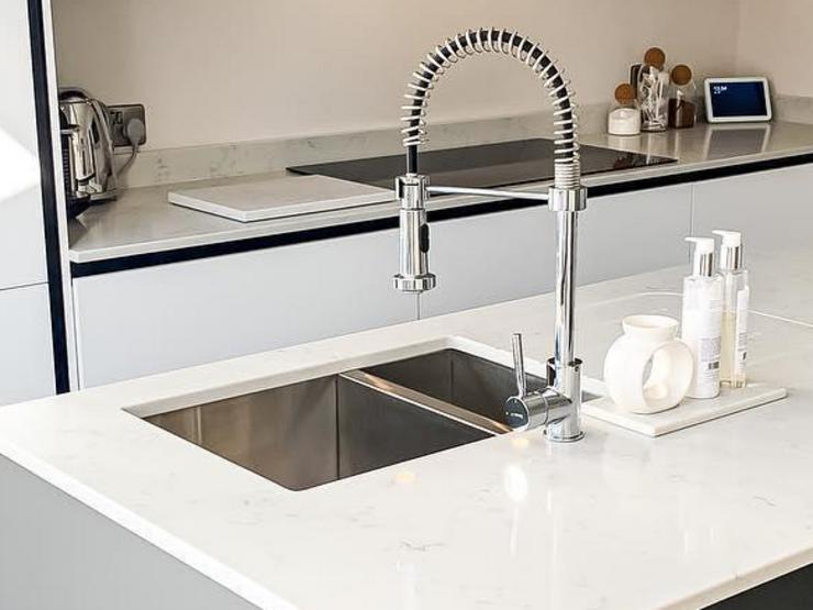 A modern kitchen sink idea using a stainless-steel sink in a 1.5 bowl style and inset design for a streamlined look.