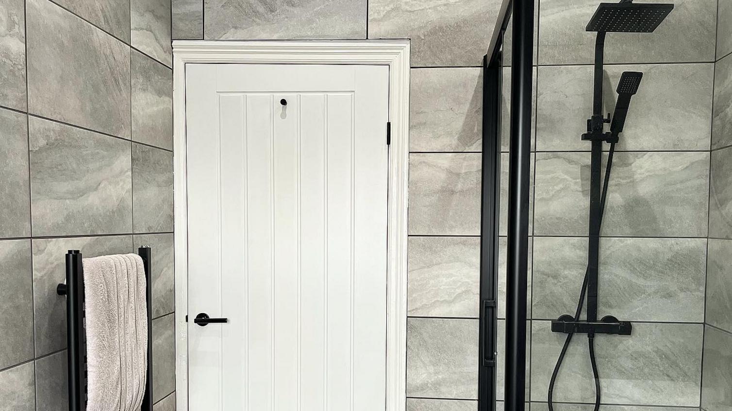 A white internal door in a modern grey bathroom