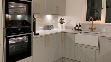 Small matt shaker kitchen in a dove grey colour from the Chelford collection. Features white worktops and brass handles.