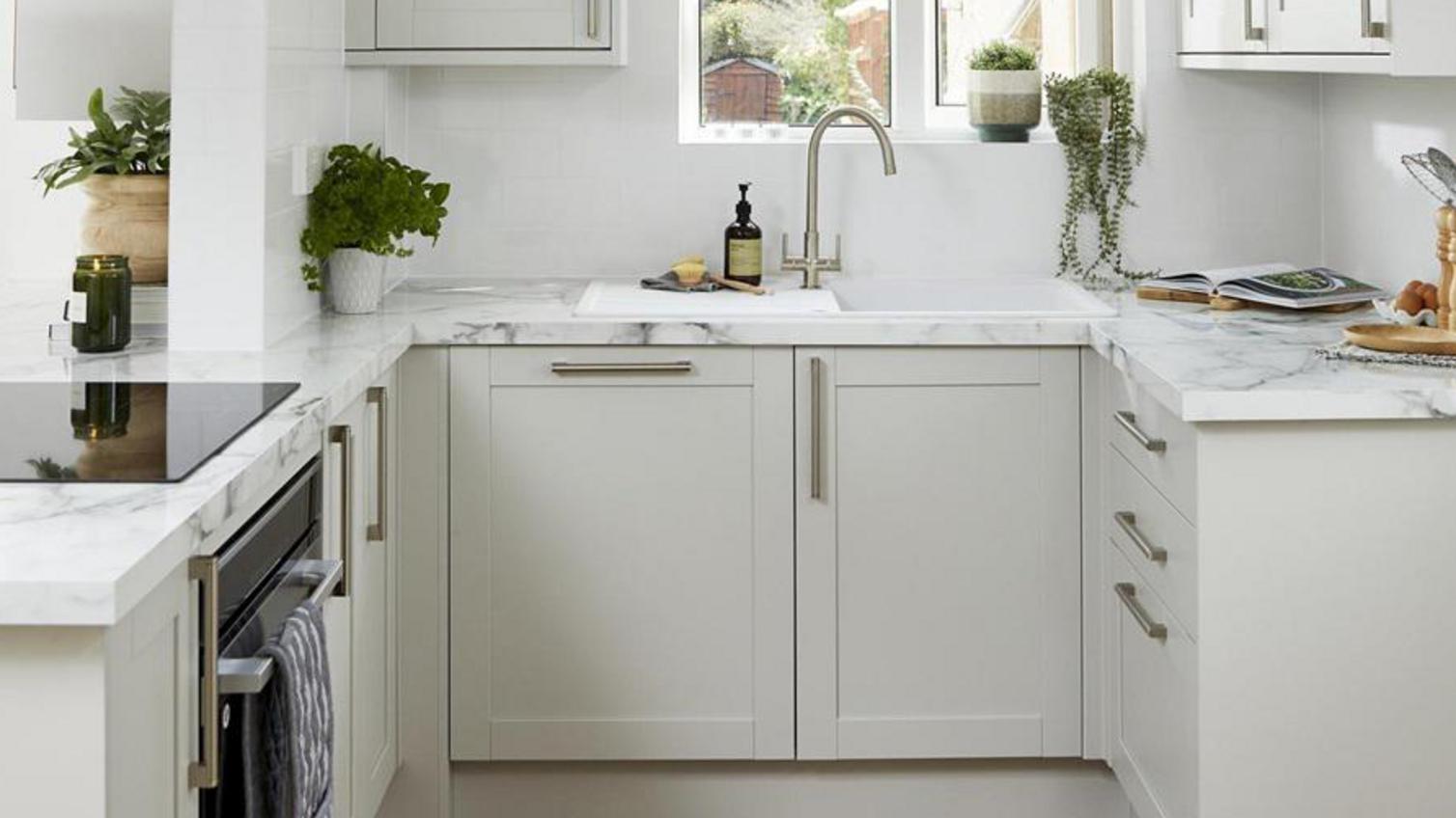 Witney small shaker kitchen, finished in a dove grey colour. Features marble-effect worktops and metallic handles.