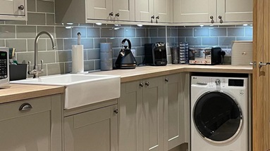 Small shaker kitchen in a matt finish, featuring a white, shallow butler sink and chrome tap.