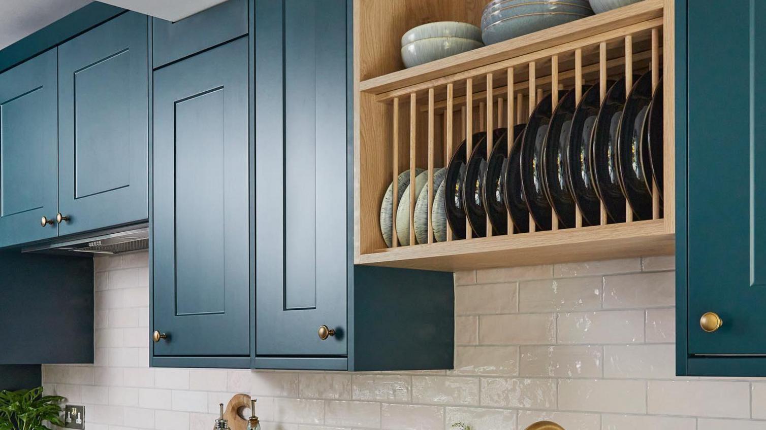 A small shaker kitchen from the Chelford marine blue range. The shot includes wall-mounted plate racks and brass accessories