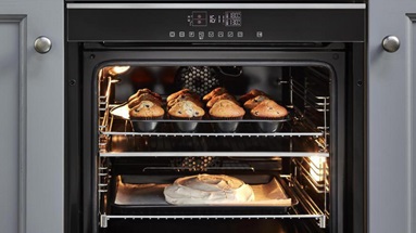 Lamona split cavity oven in a small shaker kitchen, which has a dusk blue finish and chrome accessories.