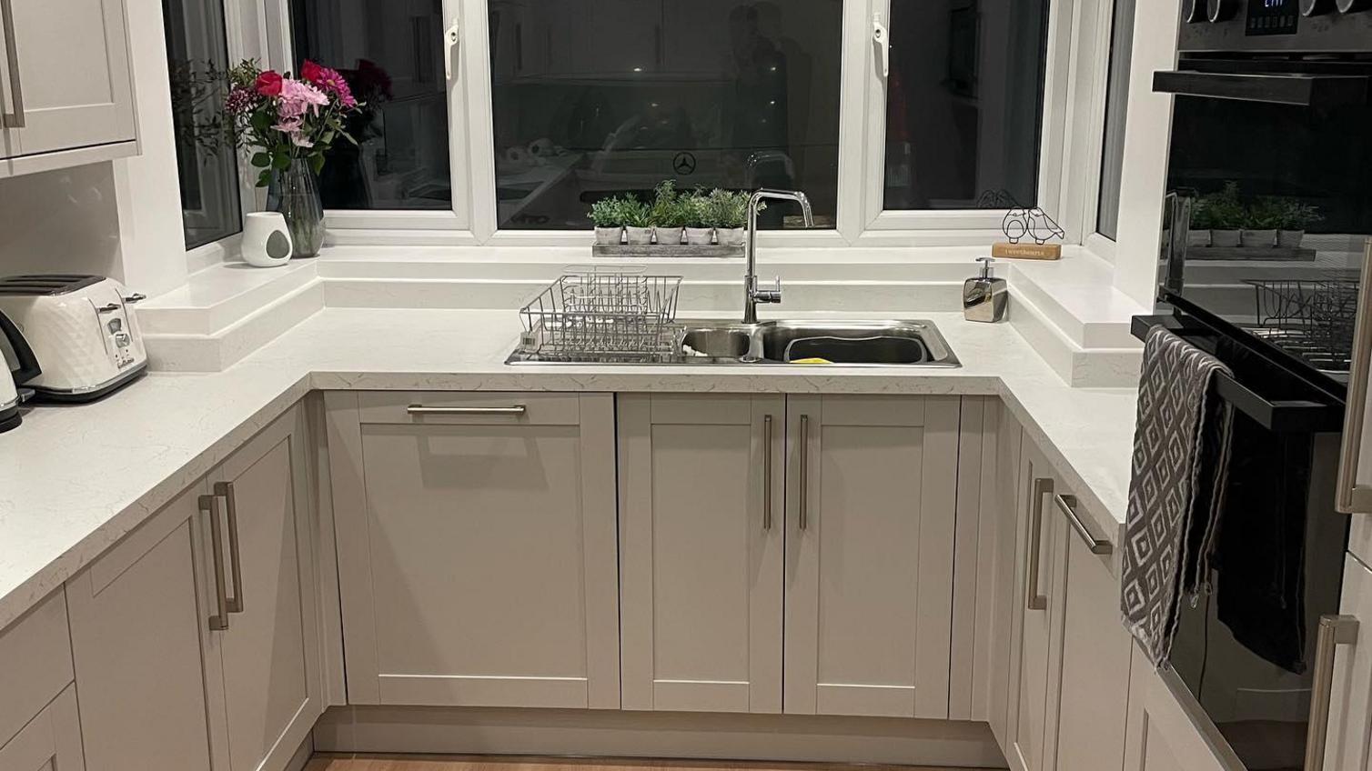 A grey shaker kitchen with a sink and tap package from Howdens