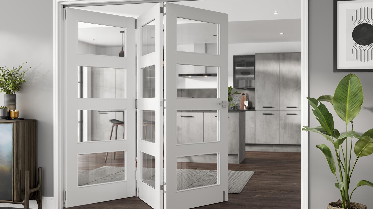 A set of white glazed doors inside a modern home, behind them is a sleek, grey kitchen and rich wooden flooring.